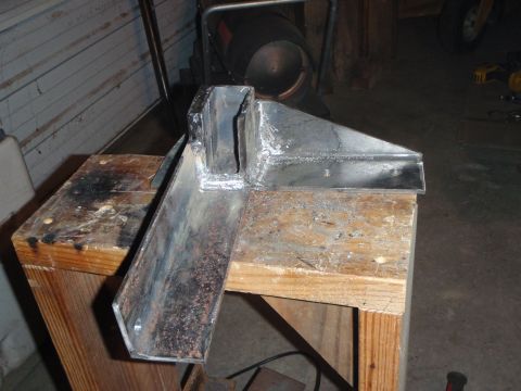 1996 Ford Bronco - A welded metal bracket is shown resting on two wooden sawhorses. The bracket appears to be custom-made and is in a workshop or garage setti…