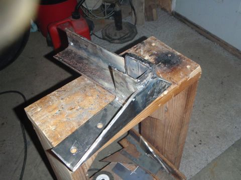 1996 Ford Bronco - A metal fabrication project is shown, with several pieces of steel angle iron welded together and resting on a wooden workbench. The scene…