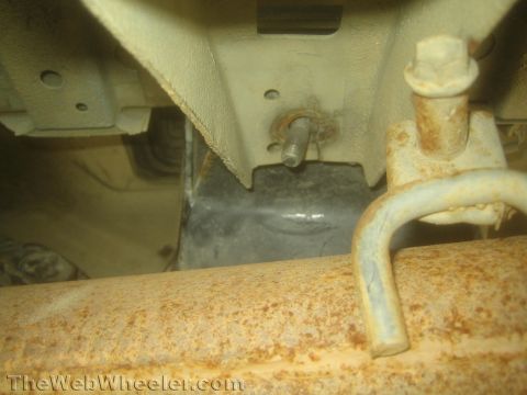 1987 Suzuki Samurai - Photo from beneath a vehicle showing exhaust pipe routing, frame and undercarriage parts.