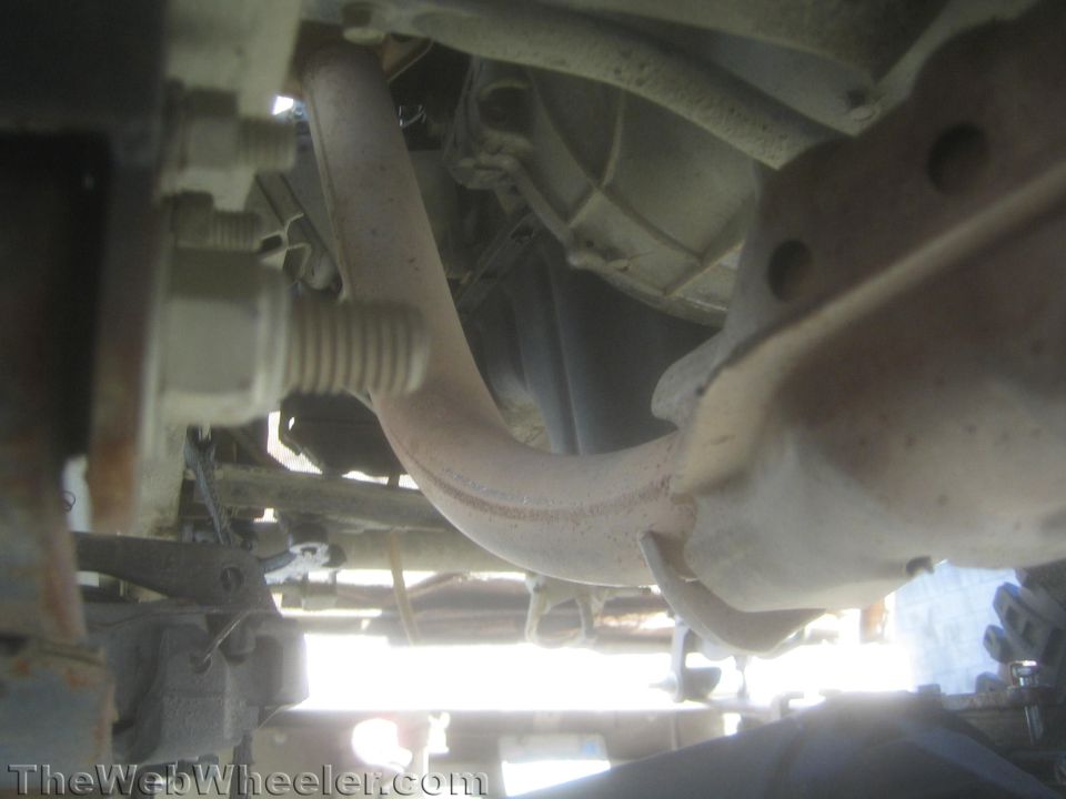 Underside view of an exhaust crossover pipe and frame