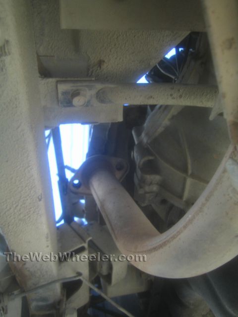 1987 Suzuki Samurai - Photo from beneath a vehicle showing a flanged exhaust pipe joint and frame structure.