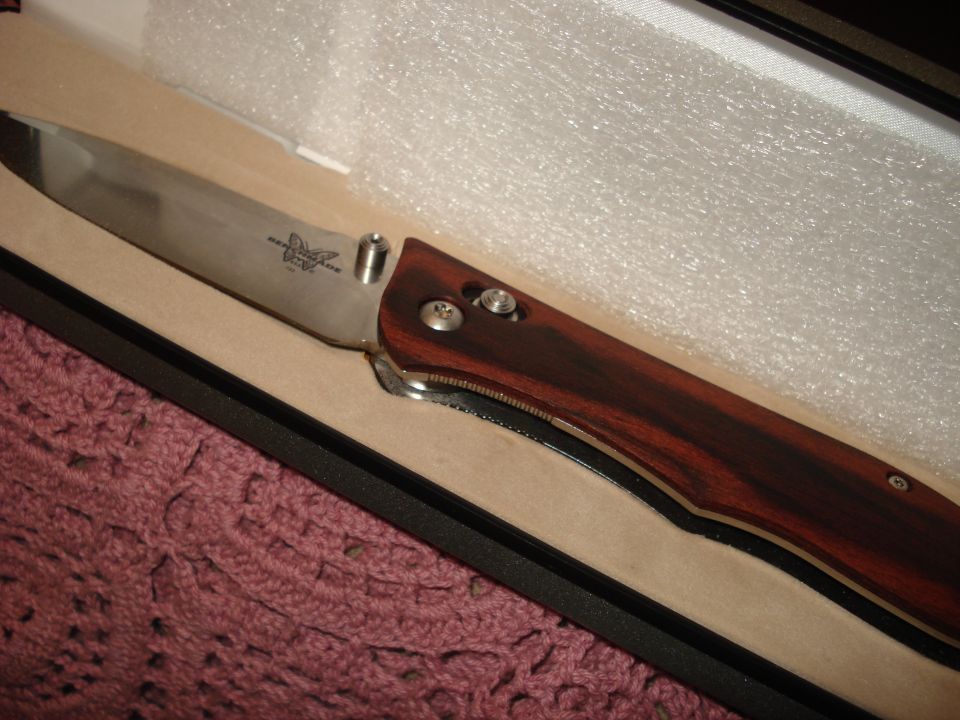 Folding knife with wooden handle and stainless steel blade in a box.