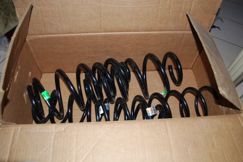 2008 Jeep Wrangler - A cardboard box contains several black coil springs, likely for a vehicle suspension system. Some of the springs have small labels attached.