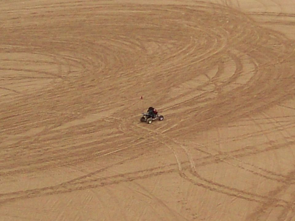 ATV with rider on sand dunes, seen from above