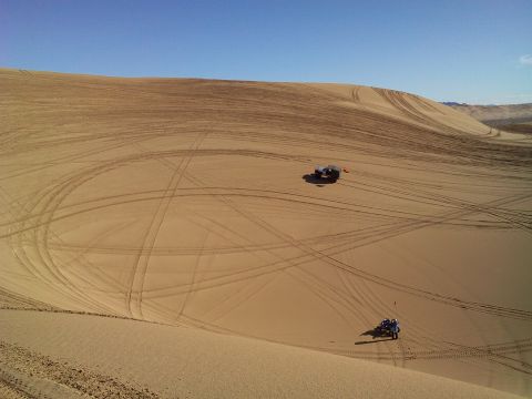 2004 Jeep Wrangler - Two off-road vehicles are parked on a vast sand dune under a clear blue sky. Tire tracks crisscross the sandy terrain, indicating recent ac…