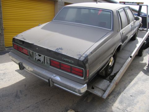 1991 Ford LTD Crown Victoria - This Chevrolet Caprice is being towed, its 'Caprice' badge is visible on the rear panel.