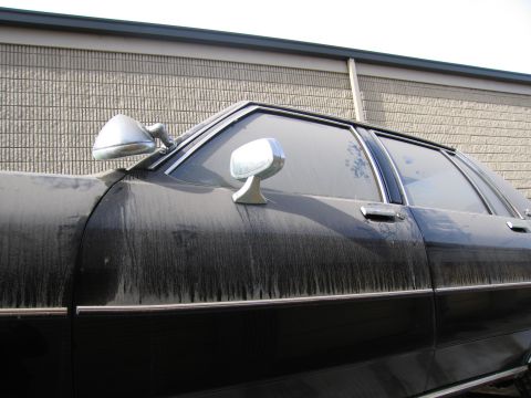 1991 Ford LTD Crown Victoria - Detail photograph of a black sedan's greenhouse and side mirror, not a technical document.