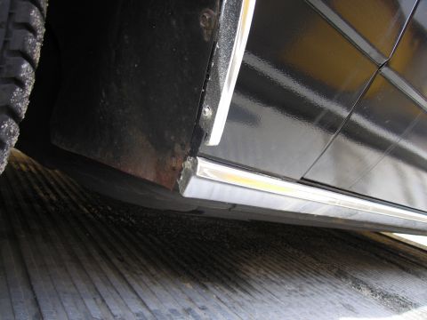 1991 Ford LTD Crown Victoria - Close-up view of the lower side panel and trim of a black vehicle.