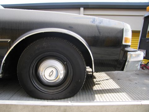 1991 Ford LTD Crown Victoria - Detail photograph of a Chevrolet front fender and wheel, not a technical document.