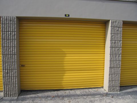 1991 Ford LTD Crown Victoria - A row of storage units, one with a bright yellow door and the number 75 above it.
