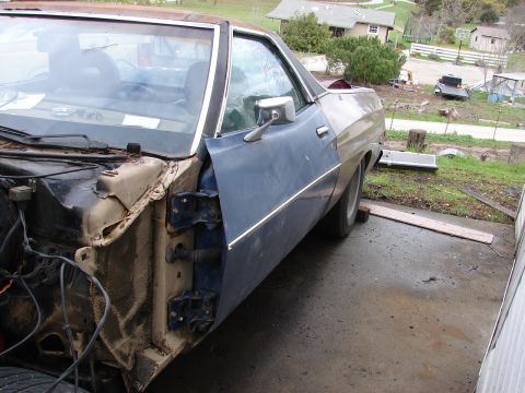1973 Ford Ranchero - A blue 1973 Ford Ranchero is seen from the side with its front end disassembled.