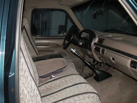 1997 Ford F-250 - The interior of a truck cab, a patterned bench seat and a floor-mounted shifter.