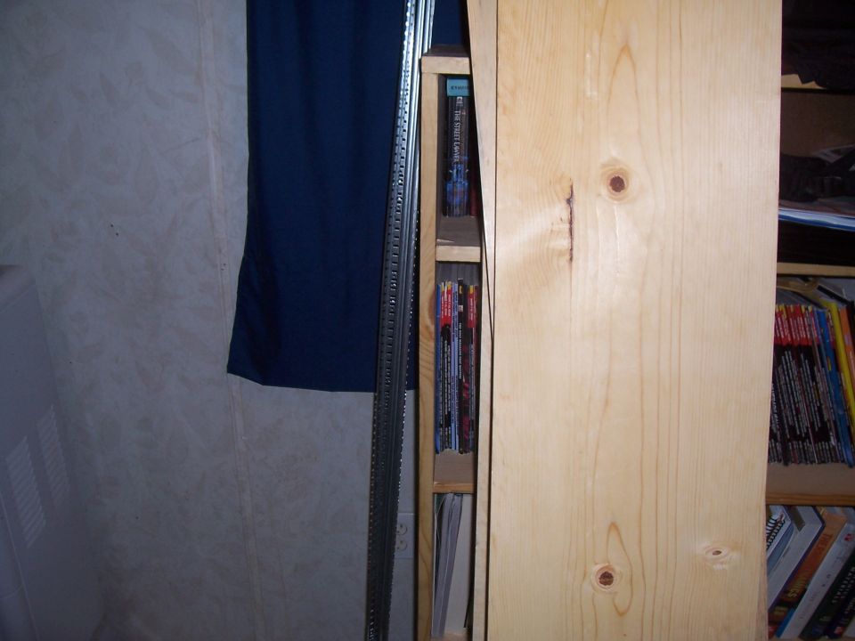Bookshelf with magazines and books. A blue curtain is on the left