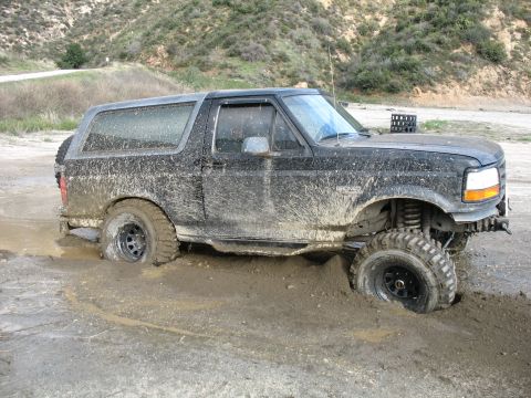 1987 Ford Bronco - This SUV is stuck deep in the mud, with only its top half visible.