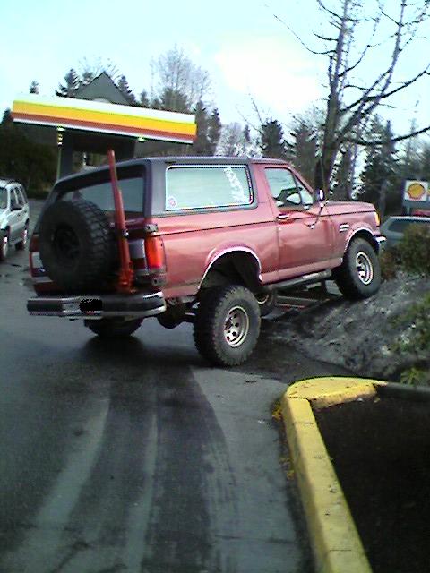 1989 Ford Bronco - Red 1989 Ford Bronco with a spare tire mounted on the back is parked at a gas station.