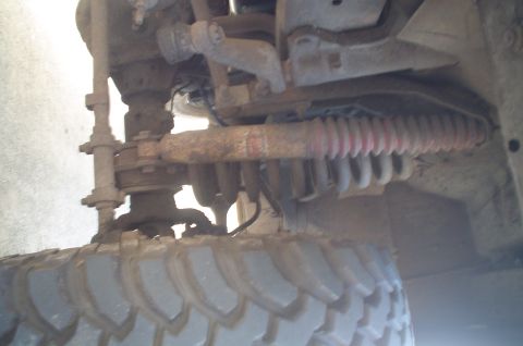 1979 Ford Bronco - Close-up of the suspension and tire assembly on a vehicle, showing mechanical components and tread detail.