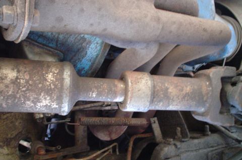 1979 Ford Bronco - Close-up view of the undercarriage of a vehicle, focusing on the exhaust and drivetrain components.