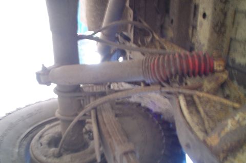 1979 Ford Bronco - Undercarriage detail of a 1979 Ford Bronco, highlighting the suspension components including the shock absorber and leaf springs.