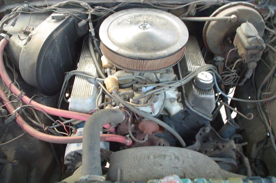 Engine bay with V8 engine, air cleaner, brake booster, and hoses
