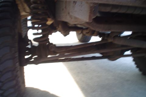 1979 Ford Bronco - Close-up view of the vehicle's undercarriage, showing suspension and drivetrain parts.