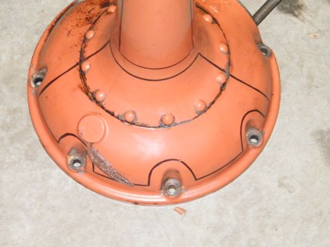 1912 Ford Model T - This orange painted metal part has bolt holes and black drawn lines, likely a component from a vehicle.