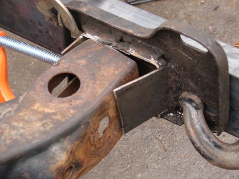 1973 Ford Ranchero - A close-up view of a metal frame part undergoing repair with welding and a threaded rod.