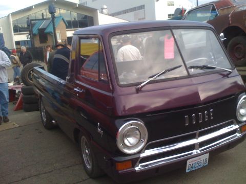 1983 Ford Bronco - A purple Dodge A100 pickup truck is parked outdoors with other vehicles and people around.