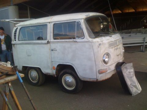1983 Ford Bronco - A weathered Volkswagen Type 2 van sits under a covered structure, with a person visible to the left.
