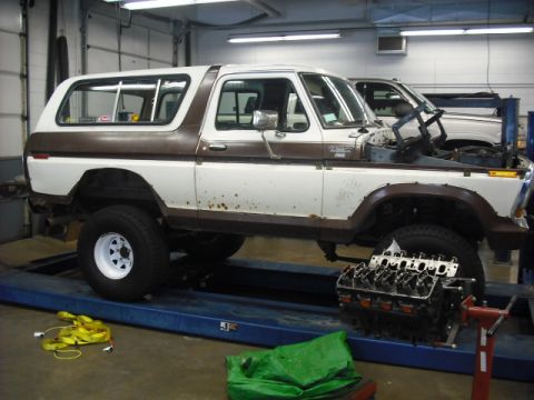 1979 Ford Bronco - 1979 Ford Bronco undergoing service in a garage, engine is out of the vehicle.