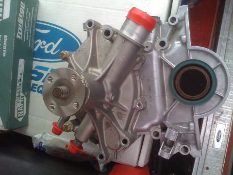 1983 Ford Bronco - A close-up view of a Ford water pump, with a Ford logo visible on a box in the background.