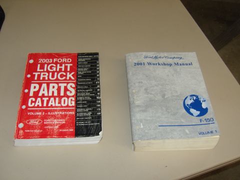 2007 Ford Mustang - Photograph of two Ford reference books, a parts catalog and a workshop manual, on a table, not a document page itself.