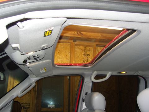 2007 Ford Mustang - Photograph of a vehicle interior headliner and open sunroof aperture, not a technical document.