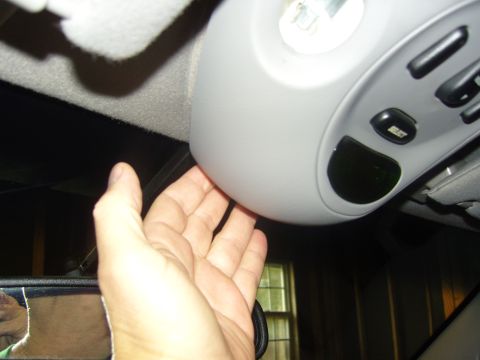 2007 Ford Mustang - Photograph of a hand at a vehicle overhead console, not a technical document.