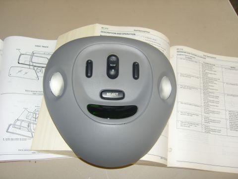 2007 Ford Mustang - Photograph of an overhead console shell on a table with a service manual open in the background, not a document page itself.