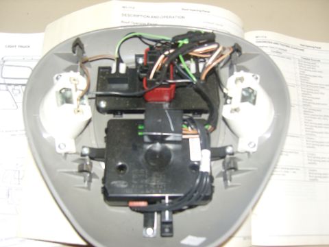2007 Ford Mustang - Photograph of an opened overhead console showing actuator motors and color-coded wiring, not a technical document.