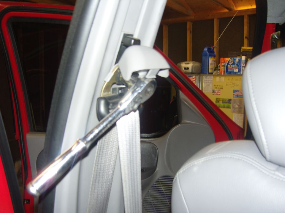 Photo of a vehicle B-pillar seat belt with a ratchet wrench