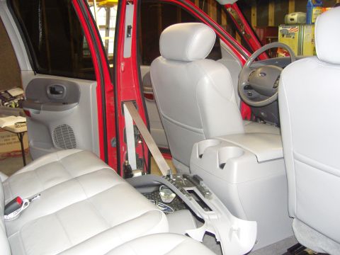2007 Ford Mustang - Photograph of the front interior of a red Ford truck with leather seats and dashboard, not a document.