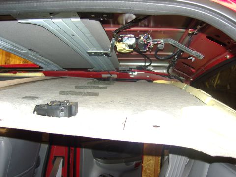 2007 Ford Mustang - Photograph of an exposed truck roof interior with wiring harness and overhead console bracket, not a document.