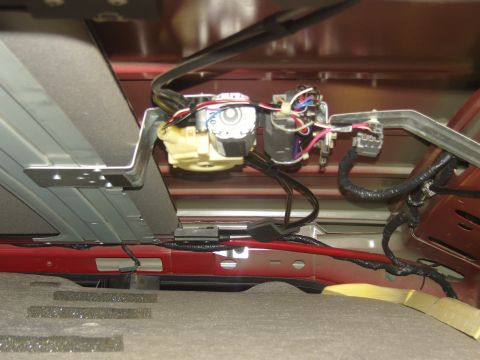 2007 Ford Mustang - Photograph of an overhead console motor, wiring harness and connectors inside a vehicle roof, not a document.