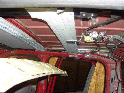 2007 Ford Mustang - Photograph of an exposed truck roof showing metal bracketry and overhead console wiring, not a document.