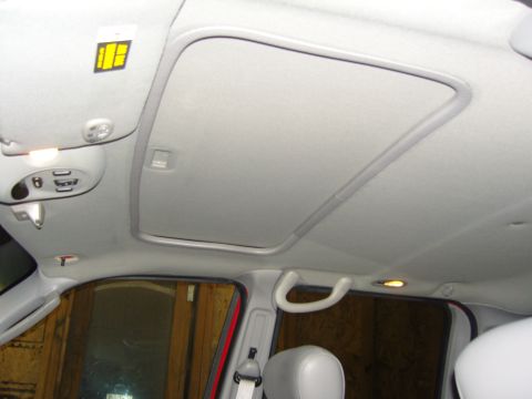 2007 Ford Mustang - Photograph of a gray vehicle headliner with sunroof opening, lights and overhead console, not a document.