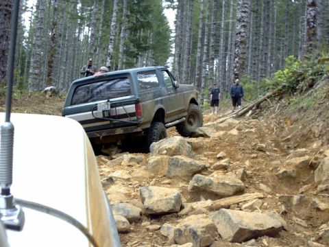 1995 Ford Bronco - Off-roading adventure in a 1995 Ford Bronco on a challenging rocky path through a forest.