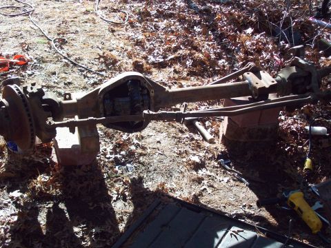 1989 Ford F-150 - A disassembled front axle assembly, likely from a 1989 Ford F-150, is resting on blocks outdoors. The differential housing is open, reveali…