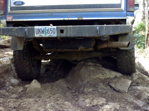 1995 Ford Bronco - This 1995 Ford Bronco is shown from the rear, tackling a challenging rocky terrain.