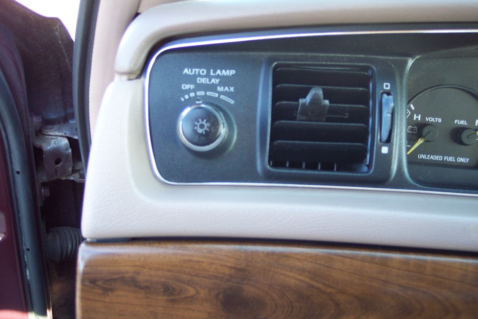 Interior dashboard of a Ford Crown Victoria with auto lamp control, air vent, and gauges.