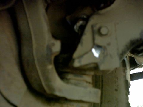 1995 Ford Bronco - Detail shot of the undercarriage, focusing on suspension parts and hardware. Text from Supermotors.net is visible.