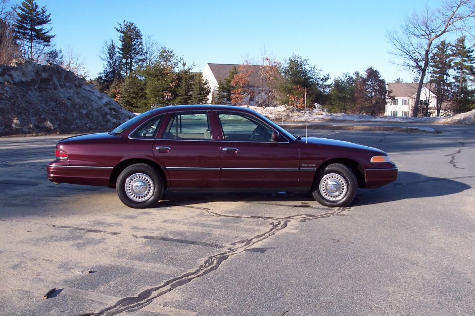 Maroon 2001 Ford Crown Victoria sedan parked on asphalt.