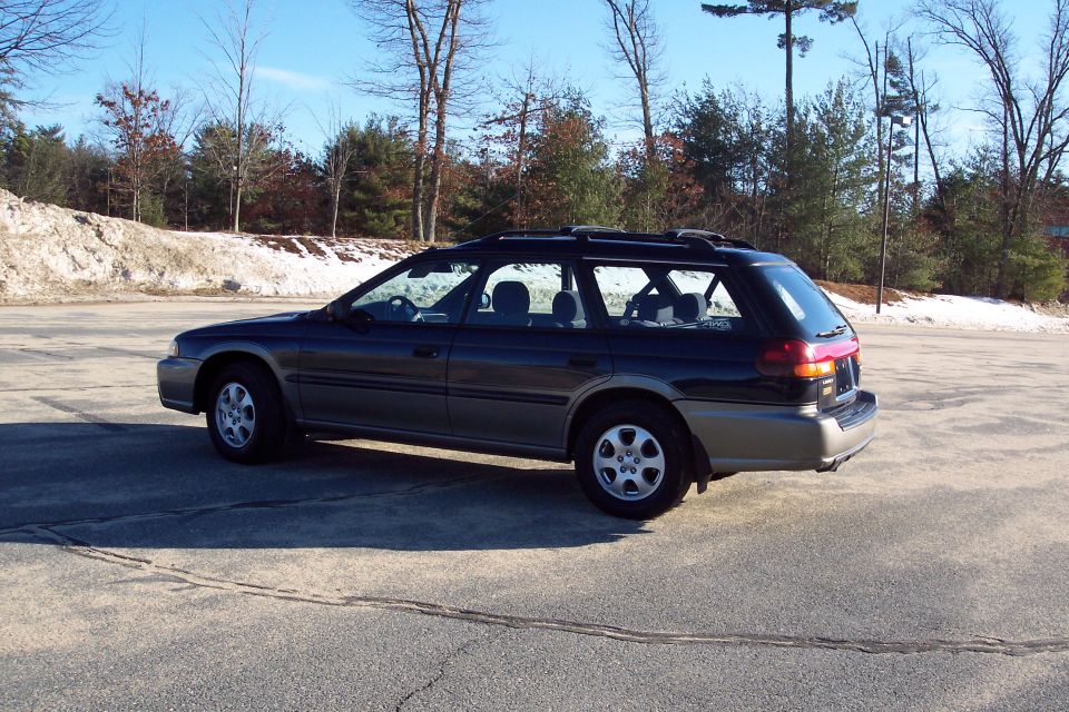 Dark blue and tan Subaru Outback wagon parked outdoors.
