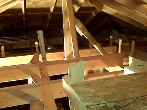 2005 Ford Mustang - The image shows the interior of an attic space with exposed wooden beams and structural supports. There are no vehicles or vehicle parts vi…