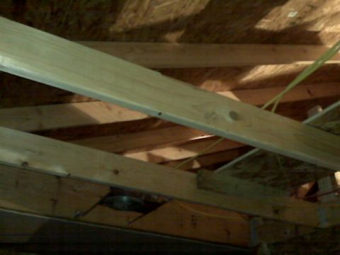 2005 Ford Mustang - The image shows the interior framing of a building, likely an attic or crawl space, with wooden beams and some electrical wiring visible.